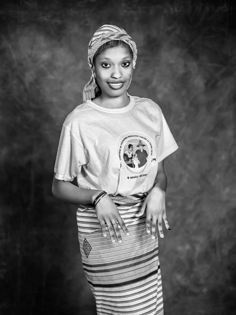 Portrait of co-founder Renata Okafor holding a multimeter in front of a wiring schematic.
