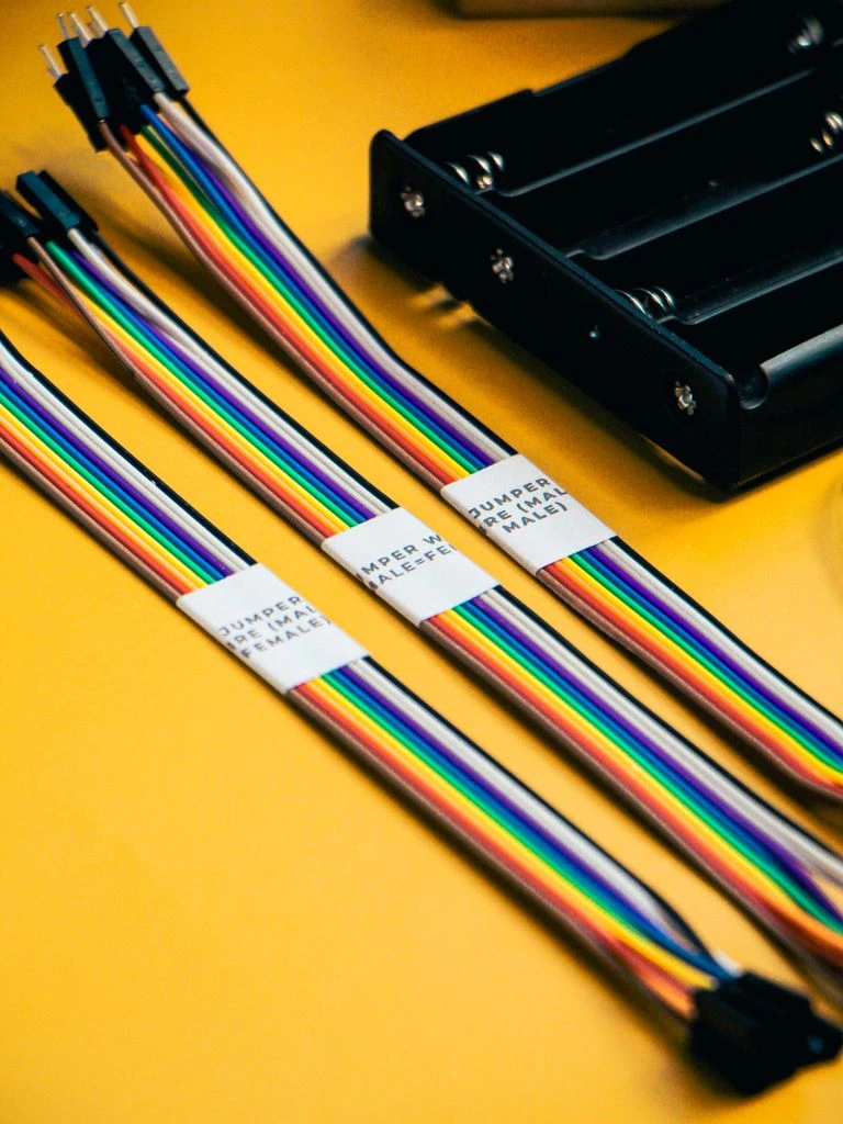 Pre-bagged dual-battery wiring harness with labeled fuses and relays on a workbench